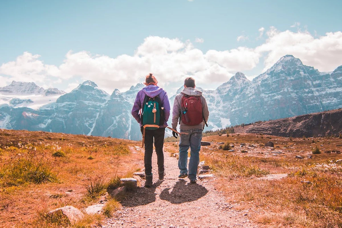 Two Person Walking on Unpaved Road in Mountain