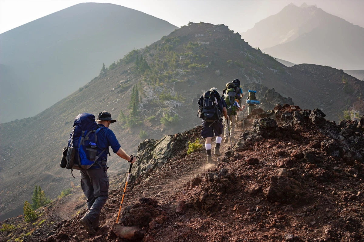 One Person Walking on Unpaved Road in Mountain